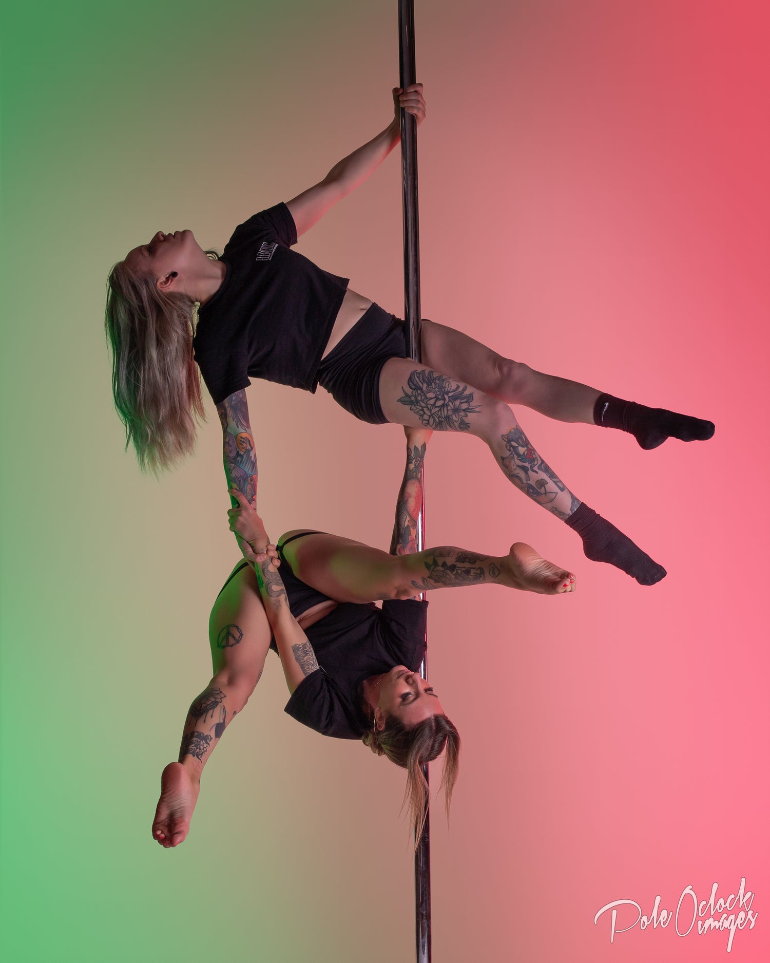 Pole studio owners performing a doubles move on a pole against a gradient background